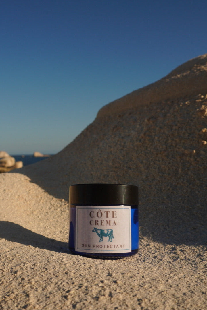 Cote Crema jar on a sandy beach with clear blue sky